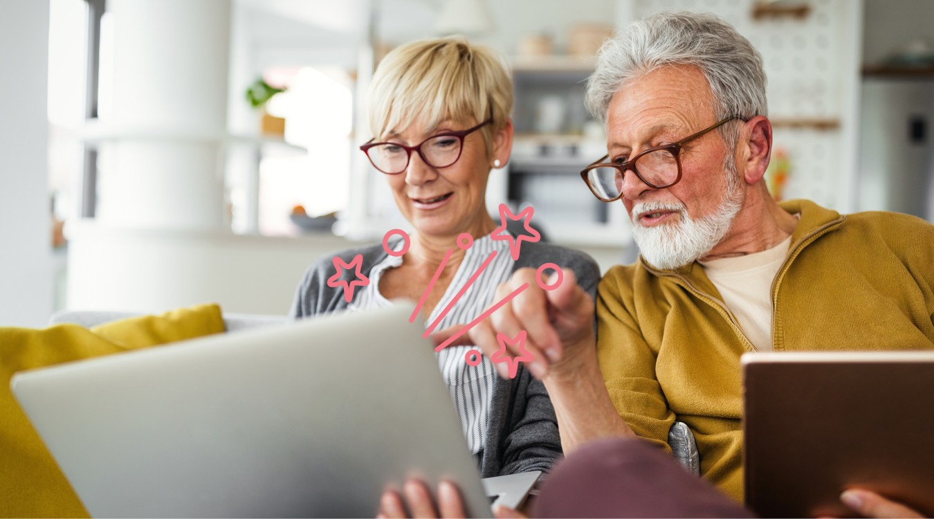 Älteres Paar sitzt auf dem Sofa vor einem Laptop